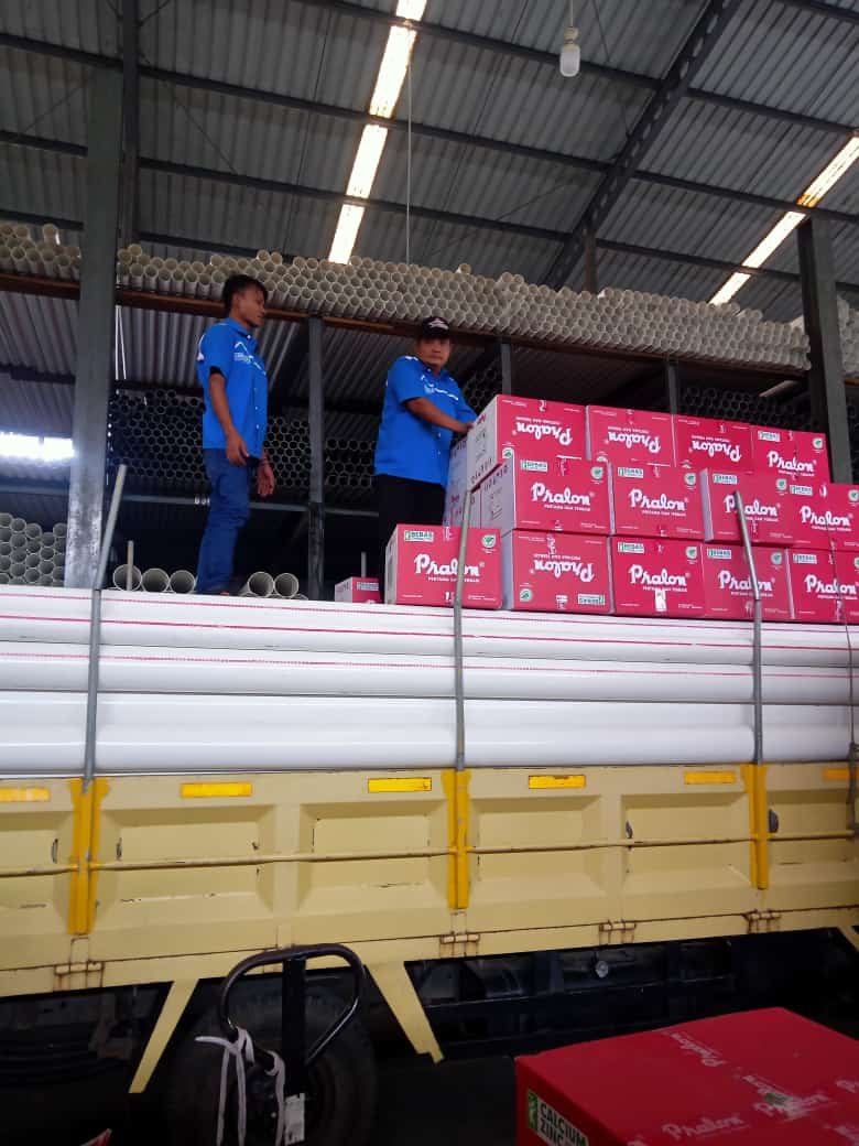 two men standing on a truck with boxes fittings pralon knee pipa pvc